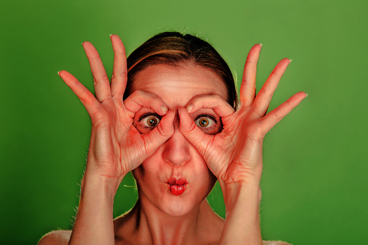 woman with big eyes on green background