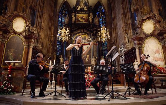 Streichquartett mit Solistin spielt ein Konzert in einer prunkvollen Kirche.