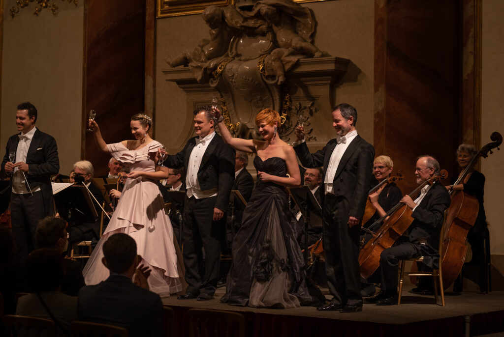 Sänger und Musiker des Wiener Hofburg Orchesters bei einer festlichen Aufführung, begleitet von einem Streichorchester